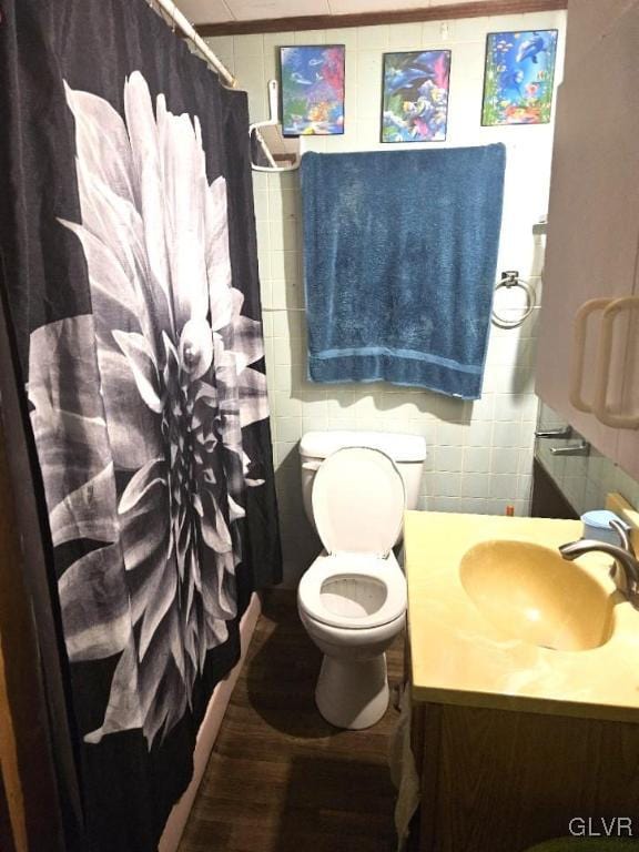 bathroom featuring tile walls, a shower with curtain, hardwood / wood-style floors, vanity, and toilet