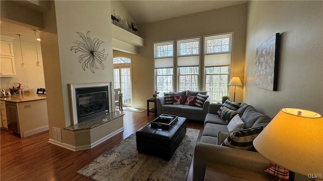 living room with dark wood-type flooring and high vaulted ceiling