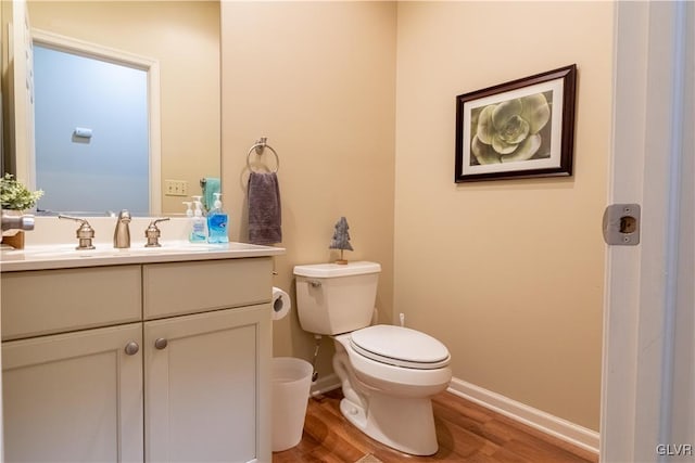 bathroom featuring wood-type flooring, vanity, and toilet