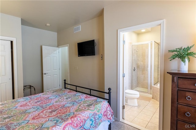 bedroom with light tile patterned floors and ensuite bathroom