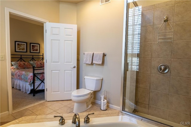 bathroom featuring tile patterned flooring, toilet, and a shower with shower door