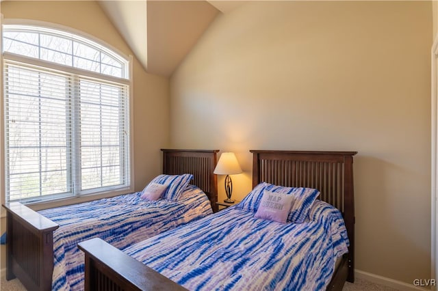 carpeted bedroom with multiple windows and vaulted ceiling