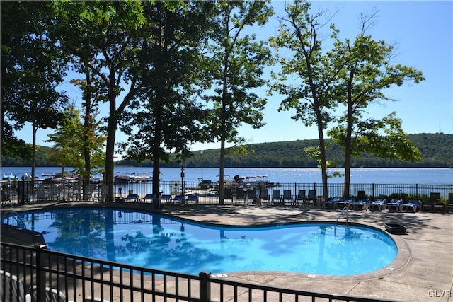 view of swimming pool with a patio and a water view