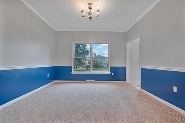 carpeted spare room with ornamental molding and a chandelier