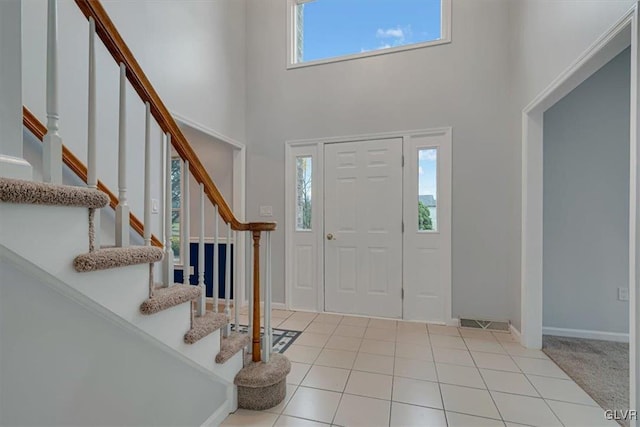 carpeted entryway featuring plenty of natural light and a towering ceiling