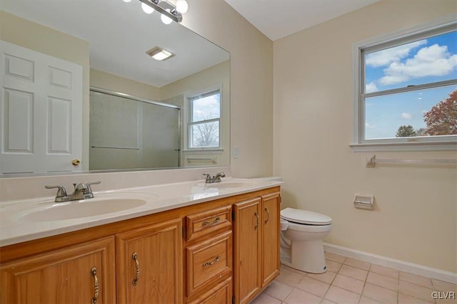 bathroom with tile patterned floors, a shower with door, vanity, and toilet