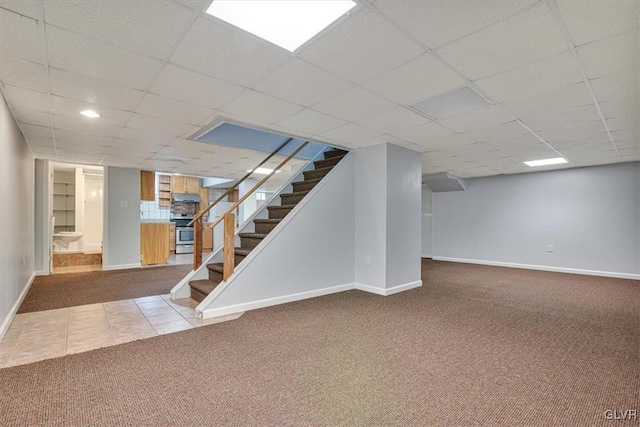 basement featuring carpet flooring and a drop ceiling