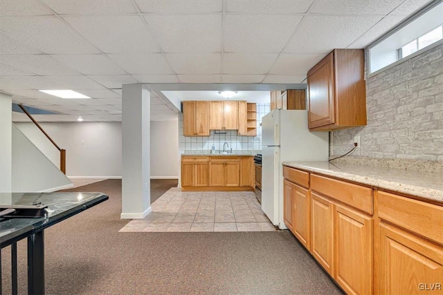 kitchen with a paneled ceiling, white refrigerator, sink, tasteful backsplash, and light colored carpet