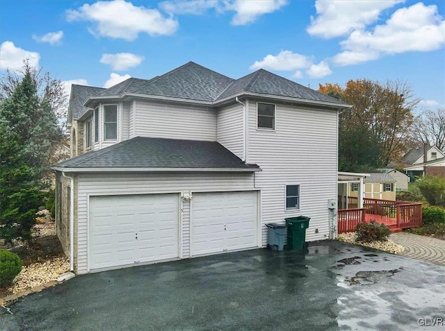 view of side of home with a wooden deck and a garage