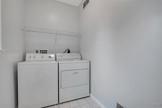 laundry area featuring separate washer and dryer and light tile patterned floors