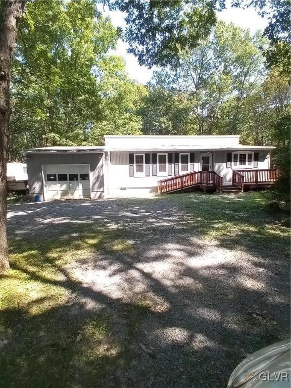 view of front of home featuring a garage and a wooden deck