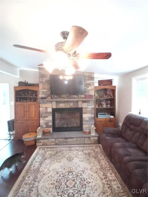 living room with wood-type flooring, a fireplace, and ceiling fan