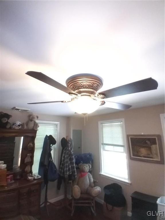 interior space featuring ceiling fan and a fireplace