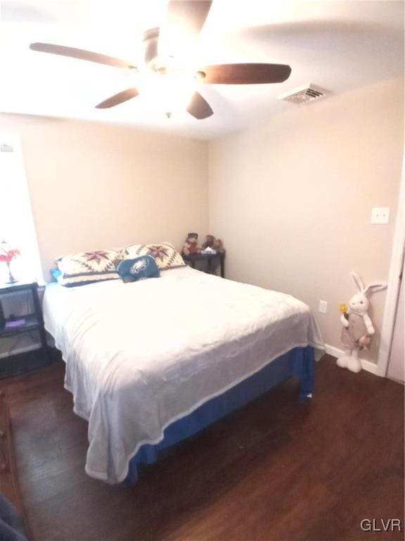 bedroom with ceiling fan and dark hardwood / wood-style floors