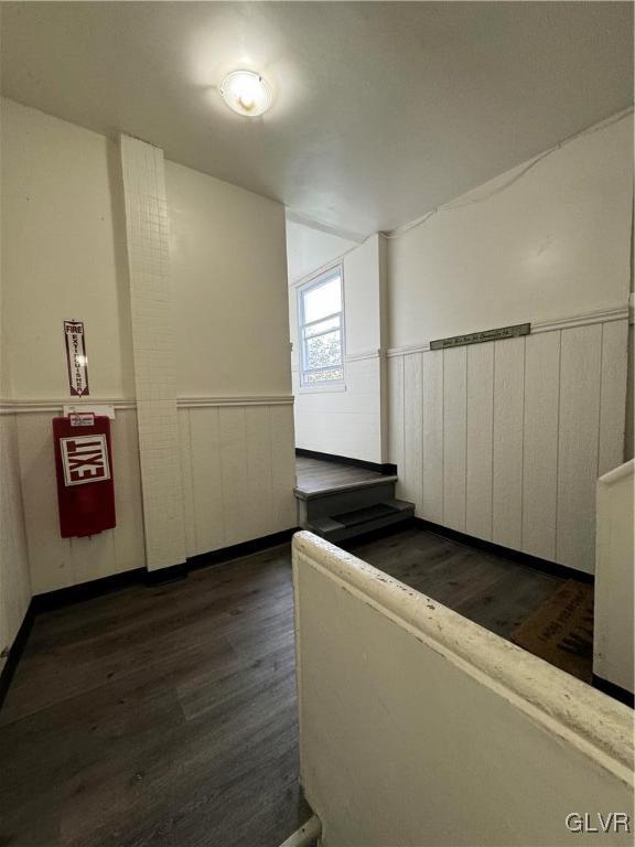 corridor with dark hardwood / wood-style flooring