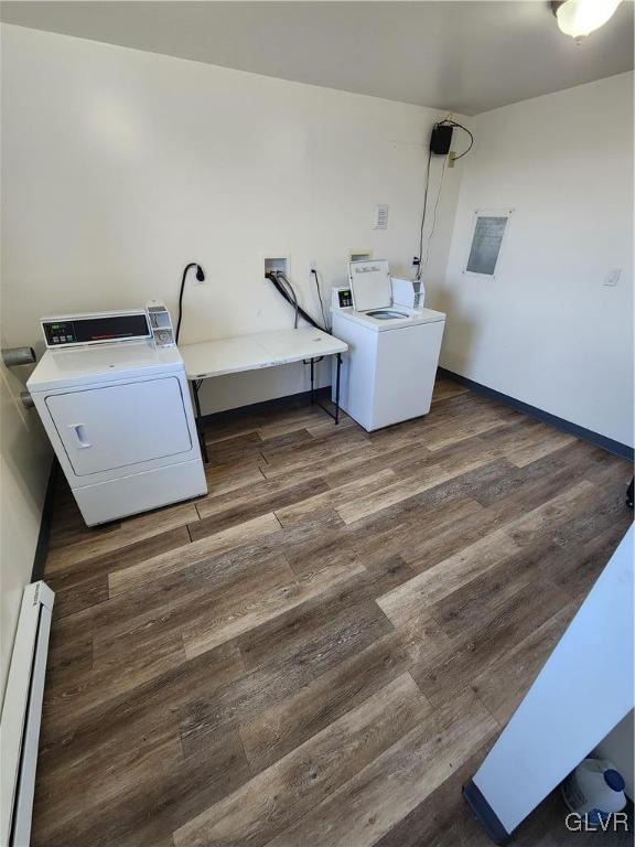 clothes washing area with baseboard heating, independent washer and dryer, and dark hardwood / wood-style flooring