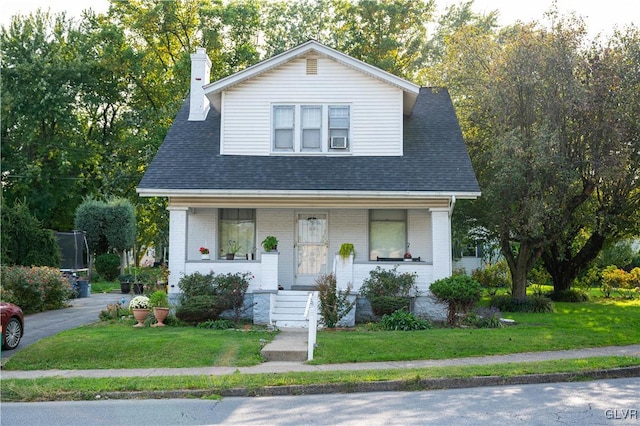 view of front of property featuring covered porch and a front yard