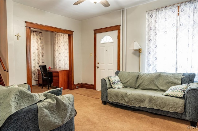 living room featuring ceiling fan, baseboard heating, carpet, and a wealth of natural light