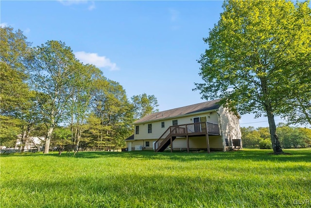 rear view of property featuring a wooden deck and a lawn