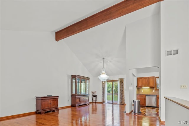 living room with light hardwood / wood-style flooring, a chandelier, beam ceiling, and high vaulted ceiling