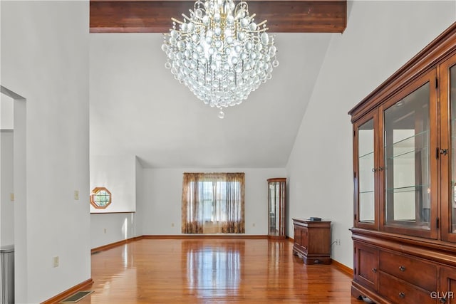 interior space with an inviting chandelier, hardwood / wood-style floors, beamed ceiling, and high vaulted ceiling