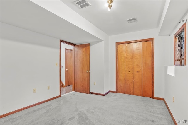 unfurnished bedroom featuring light colored carpet and a closet