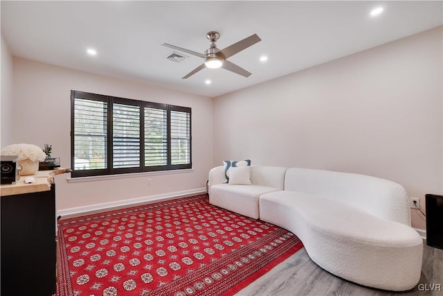 living room featuring wood-type flooring and ceiling fan