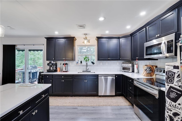 kitchen featuring light hardwood / wood-style floors, stainless steel appliances, sink, and plenty of natural light