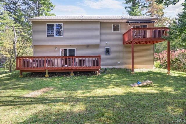 rear view of property with a deck and a lawn