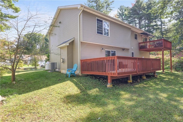 rear view of house with cooling unit, a deck, and a lawn