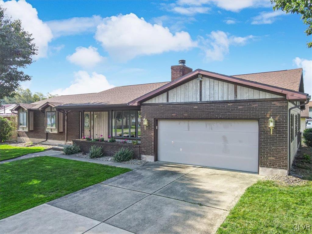 single story home with a front yard and a garage