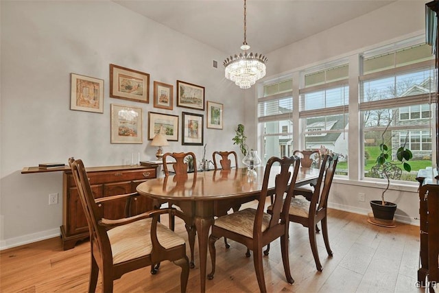 dining area featuring an inviting chandelier and light hardwood / wood-style flooring