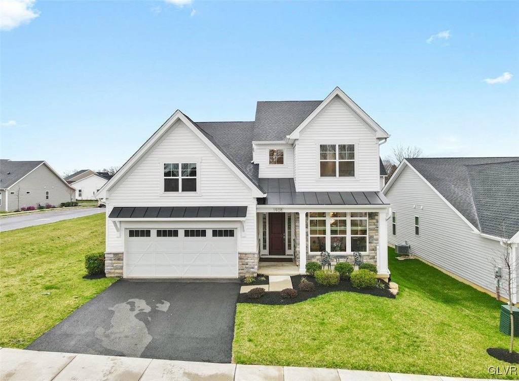 view of front of house with covered porch, a garage, and a front yard