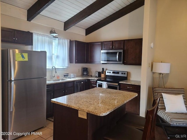 kitchen featuring dark brown cabinets, stainless steel appliances, sink, light tile patterned floors, and a center island