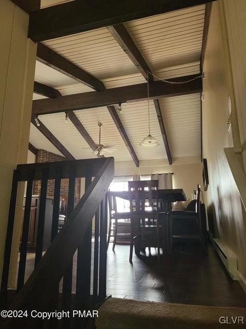 dining area with ceiling fan, dark wood-type flooring, lofted ceiling with beams, and a baseboard heating unit