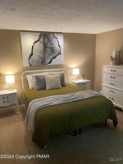 carpeted bedroom featuring a textured ceiling