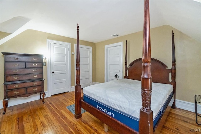 bedroom with hardwood / wood-style flooring and lofted ceiling