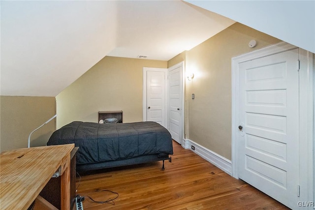 bedroom featuring hardwood / wood-style flooring and lofted ceiling