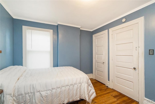 bedroom featuring ornamental molding and hardwood / wood-style flooring