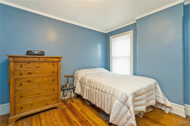 bedroom with dark hardwood / wood-style floors and crown molding