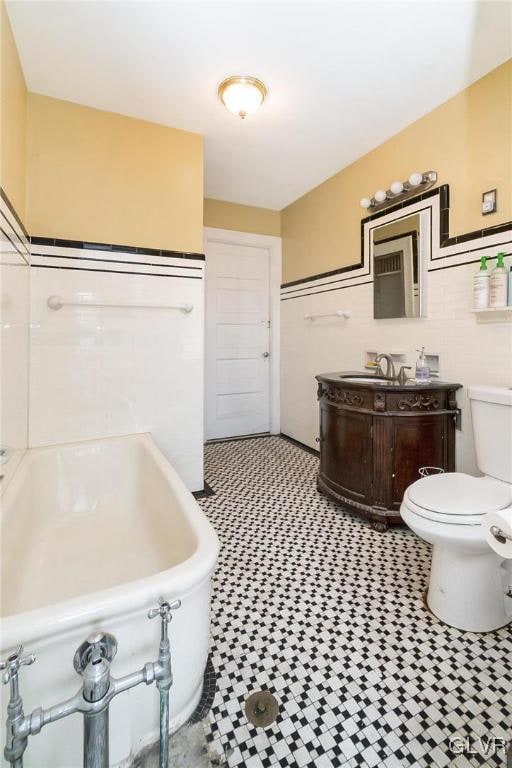 bathroom featuring a bathtub, vanity, and toilet