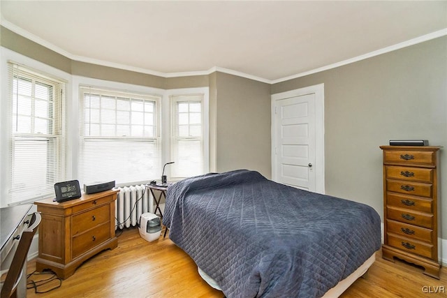 bedroom featuring crown molding, light hardwood / wood-style floors, and radiator heating unit