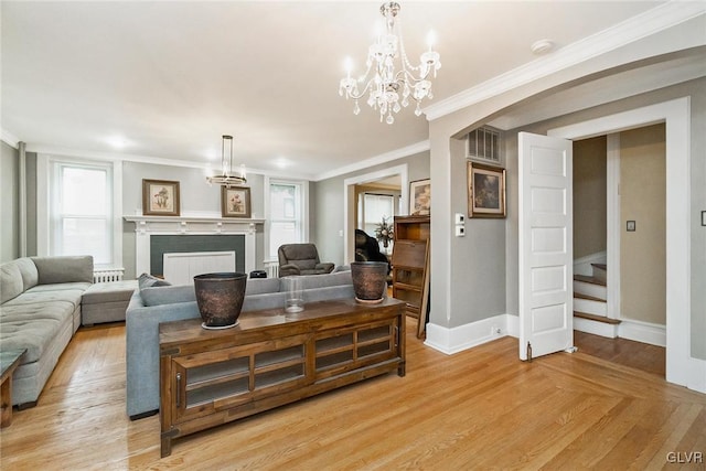 living room with a notable chandelier, light hardwood / wood-style flooring, and crown molding