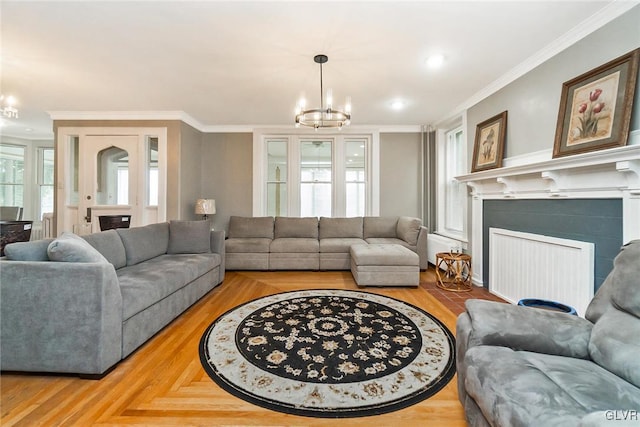 living room featuring an inviting chandelier, crown molding, and parquet floors