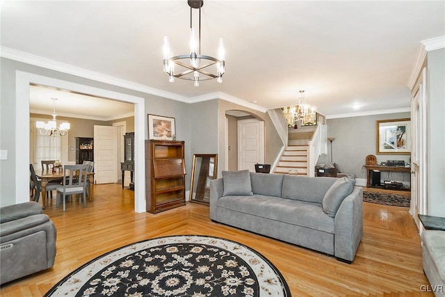 living room with a notable chandelier, hardwood / wood-style floors, and crown molding