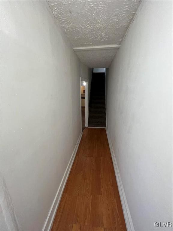 hallway featuring a textured ceiling and hardwood / wood-style flooring