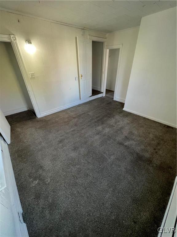 empty room featuring dark carpet