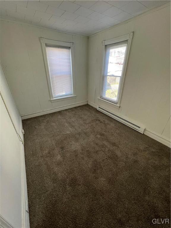 carpeted spare room featuring baseboard heating