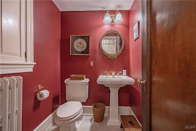 bathroom with toilet, radiator, and tile patterned floors