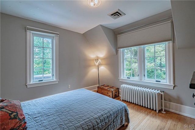 bedroom featuring light hardwood / wood-style floors and radiator